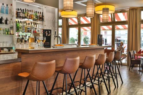 a bar with brown stools in a restaurant at Hotel Bacchus in Bensheim