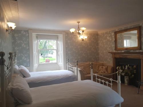 1 dormitorio con 2 camas y ventana en Plough Hotel, en Kirk Yetholm