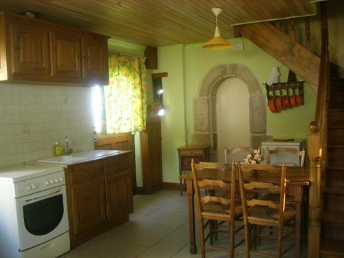cocina con mesa y horno de fogón blanco en maison kerivarch G, en Saint-Pol-de-Léon