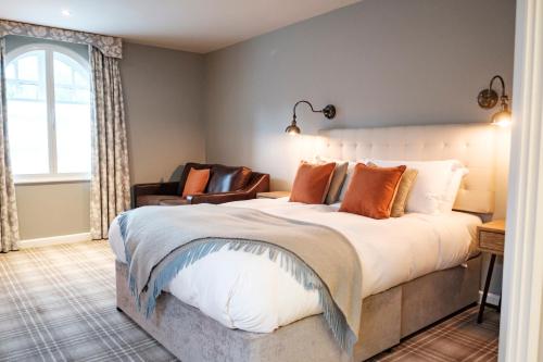 a bedroom with a large bed and a chair at The Princess Royal in Farnham