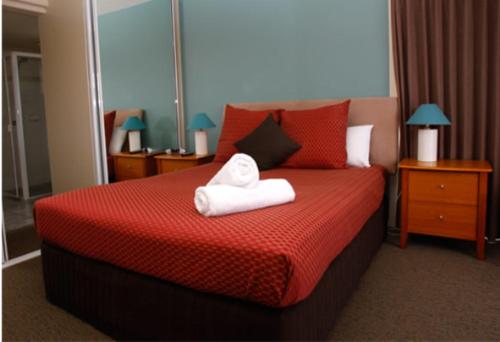 Una habitación de hotel con una cama con toallas. en Waterview Luxury Apartments, en Merimbula
