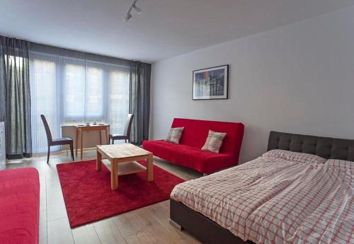 ライプツィヒにあるApartments Zentrum Brühlのベッドルーム(赤いベッド1台、赤いソファ付)