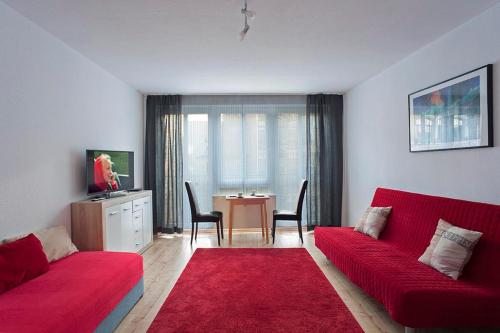 un soggiorno con un divano rosso e un tavolo di Apartments Zentrum Brühl a Lipsia