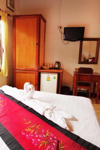 a bedroom with a bed with white sheets and a red blanket at Villa Rattanakon in Luang Prabang