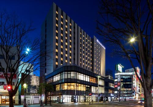 a tall building in a city at night at Daiwa Roynet Hotel Koriyama Ekimae in Koriyama