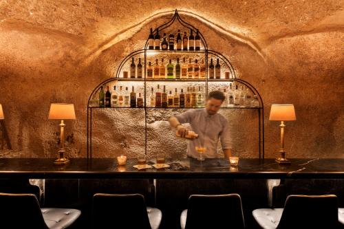 a man standing at a bar making a drink at Villa Brown Jerusalem, a member of Brown Hotels in Jerusalem