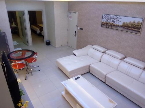 a living room with a white couch and a table at Golden Leaves Hotel in Malacca