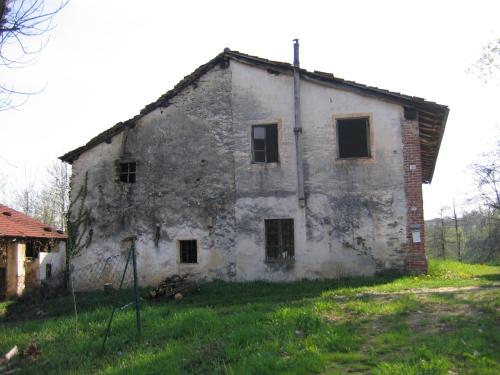 an old stone building in the middle of a field at Alpuntogiusto in Peveragno
