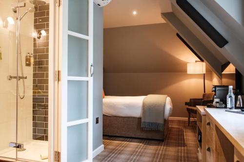 a bathroom with a shower and a bed in a room at The Princess Royal in Farnham
