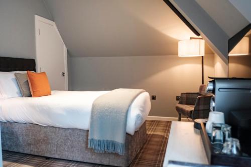 a hotel room with a bed and a chair at The Princess Royal in Farnham