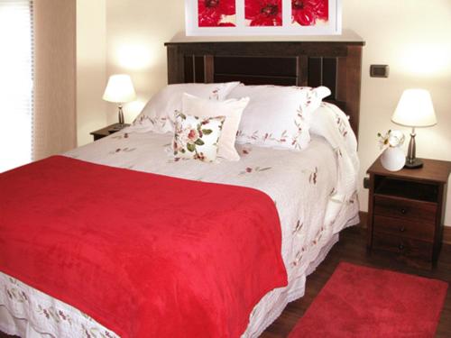 a bedroom with a red and white bed with pillows at Barceló Suites Providencia I in Santiago