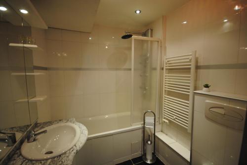 une salle de bain avec un lavabo, une douche et une baignoire dans l'établissement Le Gambetta 2P 262, à Cannes