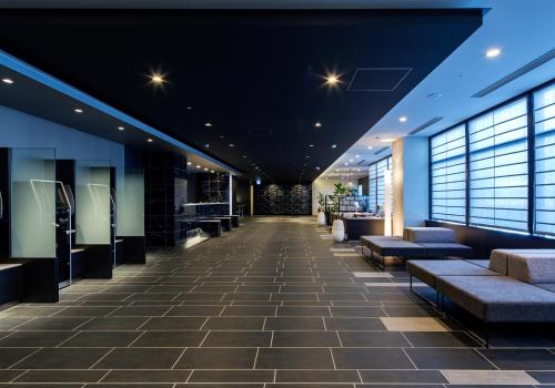 a lobby with couches and windows in a building at Daiwa Roynet Hotel Koriyama Ekimae in Koriyama