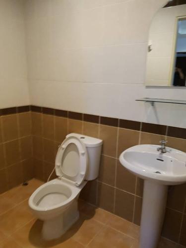 ein Badezimmer mit Toilette und Waschbecken in der Unterkunft SB Mansion in Buriram