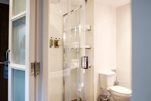 a bathroom with a toilet and a glass shower at The Princess Royal in Farnham