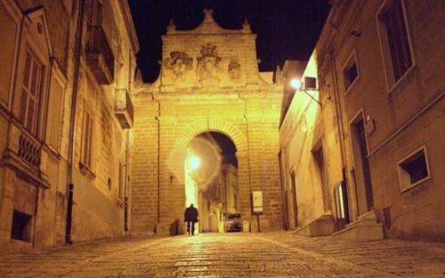 une personne se promenant dans une ruelle la nuit dans l'établissement b&b porta nuova mesagne, à Mesagne