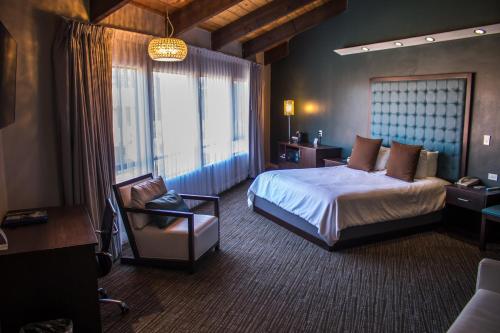 Habitación de hotel con cama y silla en Munras Inn en Monterey