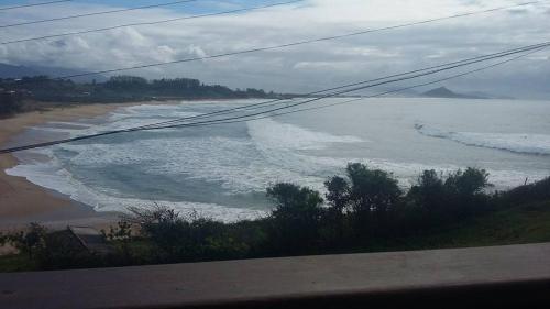 Elle offre une vue sur une plage avec une étendue d'eau. dans l'établissement Tranquilidade na Praia da Gamboa, à Garopaba