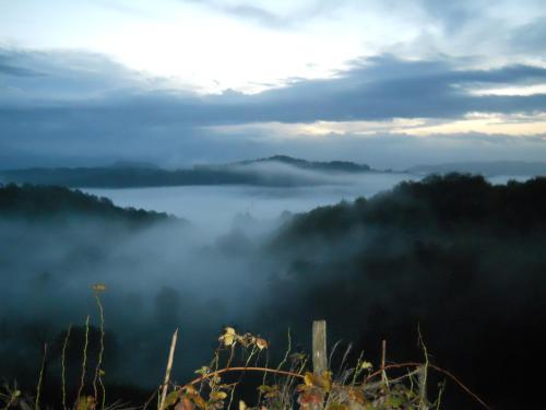 a view of a foggy valley with a lake in the background at Casa Quaratica in Riccò del Golfo di Spezia