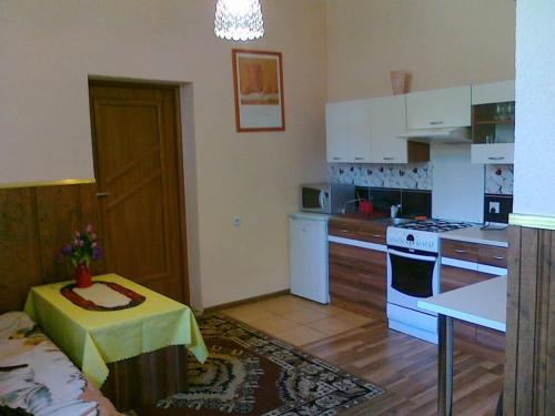 a kitchen with white cabinets and a table with a yellow table cloth at Apartamenty w Karkonoszach in Miłków
