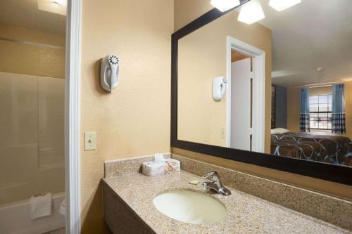 a bathroom with a sink and a large mirror at Super 8 by Wyndham Henryetta in Henryetta