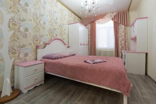 アストラハンにあるApartments Lux pl.Lenina 12/1のベッドルーム(ピンクベッド1台、ドレッサー付)