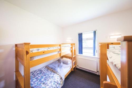 a bedroom with two bunk beds and a window at White Park Bay Youth Hostel in Ballintoy