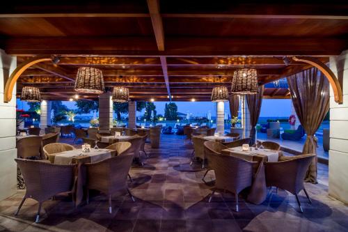 an outdoor dining area with tables, chairs and umbrellas at Dion Palace Resort and Spa in Limani Litochorou
