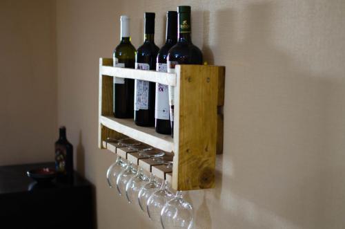 a wine bottle holder on the wall with wine glasses at U&O Apartment, Liberty Square in Tbilisi City