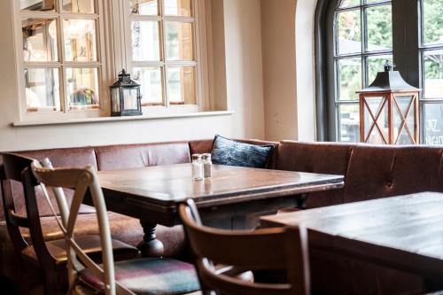 a restaurant with a wooden table and a couch at The Princess Royal in Farnham