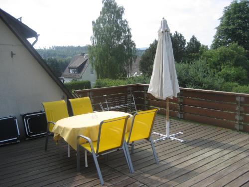 une table, des chaises et un parasol sur une terrasse dans l'établissement Ferienwohnung Wölfel, à Schwarzenbach an der Saale