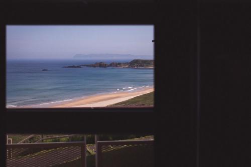 a view of a beach from a window at White Park Bay Youth Hostel in Ballintoy