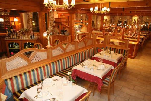 a restaurant with two tables in a room at Hotel Neuwirt in Ramsau am Dachstein