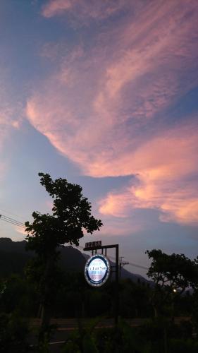 a lit up sign in front of a sunset at Ho Hai Yan Homestay in Chenggong