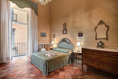 a bedroom with a bed and a dresser and a mirror at Arthouse Lady Marys Tribunali Luxury Suite in Naples