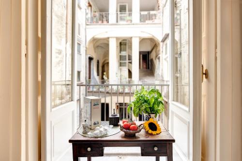 a table with a bowl of fruit on a balcony at Arthouse Lady Marys Tribunali Luxury Suite in Naples