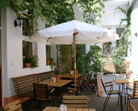 a patio with tables and chairs and an umbrella at Hotel Restaurant Frankenturm in Trier