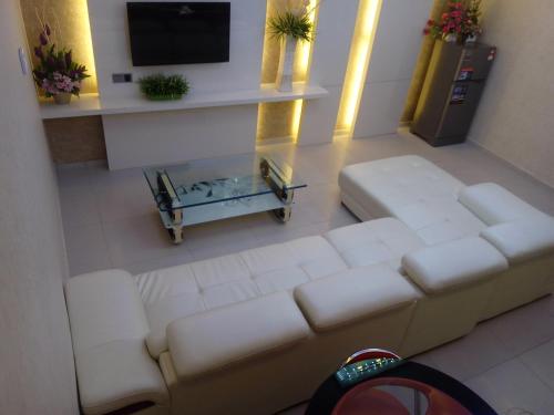 ein Wohnzimmer mit einem weißen Sofa und einem Tisch in der Unterkunft Golden Leaves Hotel in Malakka
