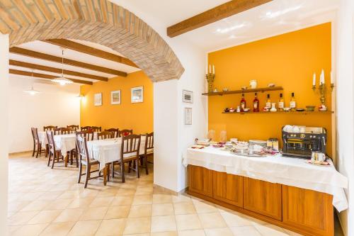 un comedor con una mesa larga con mesas y sillas blancas en Villa Cavour, en Comacchio