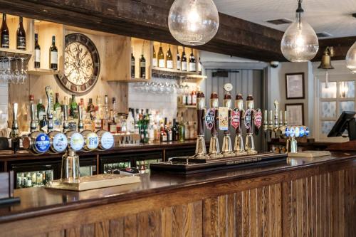 a bar with a large clock on the wall at The Princess Royal in Farnham