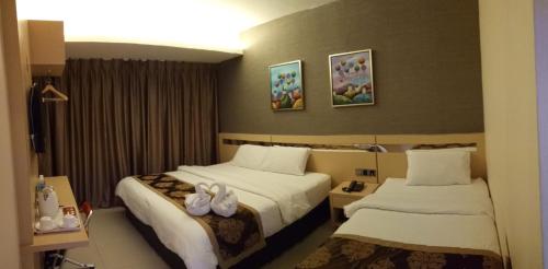 a hotel room with two beds with towels at Golden Leaves Hotel in Malacca