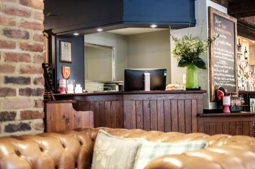 a bar with a couch in front of a mirror at The Princess Royal in Farnham
