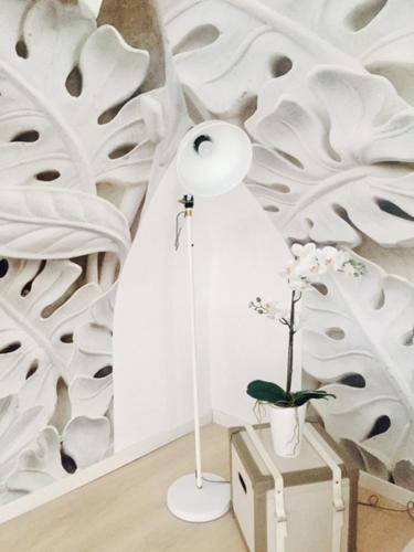 a lamp and a plant in a room with a wall at S'O Smart B&B Tropea in Tropea