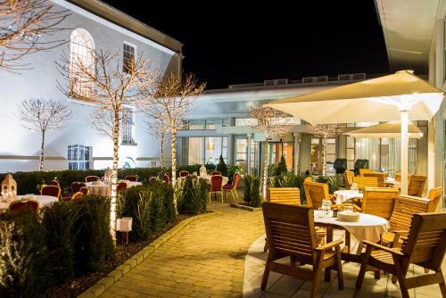a patio with tables and chairs and an umbrella at Radisson Blu Hotel, Cork in Cork