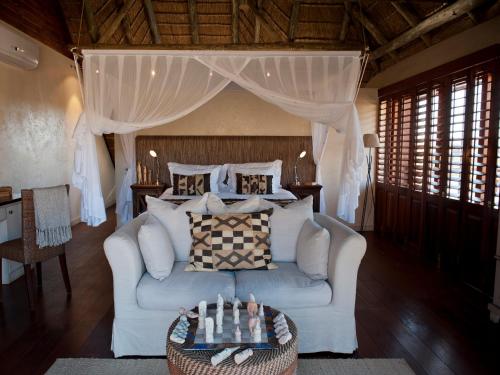 a living room with a couch and a bed at Tutwa Desert Lodge in Augrabies