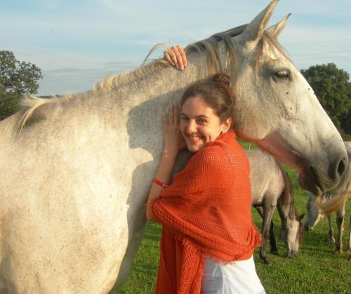 a woman standing next to a white horse at Kerca Bio Farm in Kercaszomor