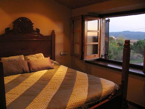 Un dormitorio con una cama grande y una ventana en Pla de Moixons, en Oristà
