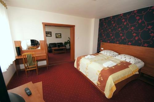 レンボルクにあるHotel Vegaのベッドとリビングルームが備わるホテルルームです。