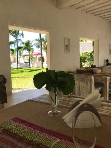 wazon z rośliną siedzącą na stole w obiekcie The Villa Luxury Suites Hotel w mieście Diani Beach