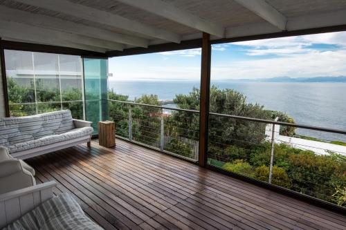 a balcony of a house with a view of the ocean at Quarterdeck Holiday Apartment in Simonʼs Town